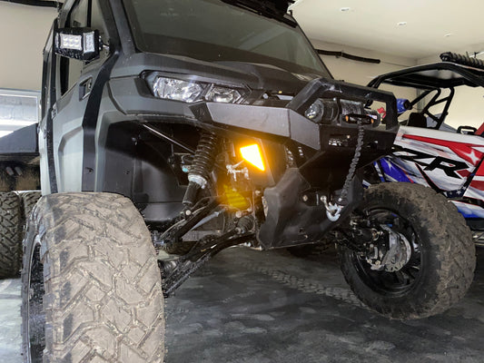A black Can am Defender with a lift kit installed