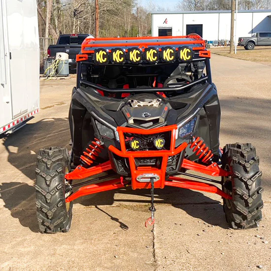 Red Can-Am Maverick X3 on paved driveway